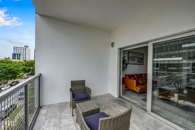 a balcony with chairs and a couch on it at Subtle 2 Bed in Edgewater near Downtown With Free Parking in Miami