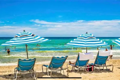 a group of chairs and umbrellas on a beach at Contemporary Beach Retreat, Sleek Design & Full Kitchen -A in Hallandale Beach