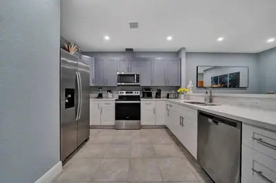 a kitchen with white cabinets and stainless steel appliances at Luxury Duplex in Heart of Fort Lauderdale Near The Beach in Fort Lauderdale