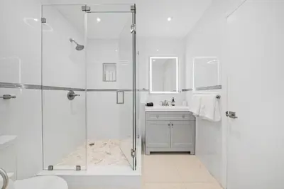 a white bathroom with a shower and a sink at Luxury 7BR Villa Vizcaya Pool Sauna Gym Golf in Miami