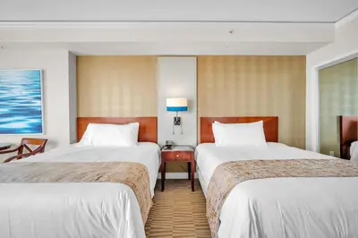 a hotel room with two beds and a desk at TRUMP INTERNATIONAL BEACH RESORT 2 BEDROOM APARTMENT 1600 Sqf OCEAN FRONT in Miami Beach