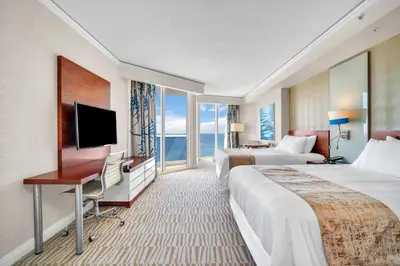 a hotel room with two beds and a flat screen tv at TRUMP INTERNATIONAL BEACH RESORT 2 BEDROOM APARTMENT 1600 Sqf OCEAN FRONT in Miami Beach
