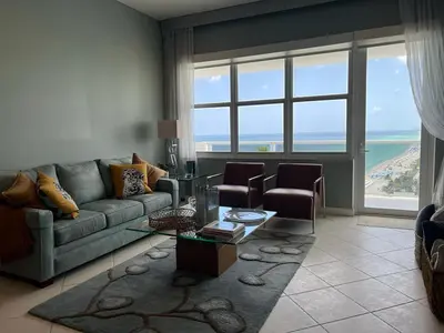 a living room with a couch and a large window at Penthouse Beach Front 1st line, 2 BR, 2 BA, New Decoration & Furnitures, unobstructed view of the beautiful Atlantic, free parking in Hollywood