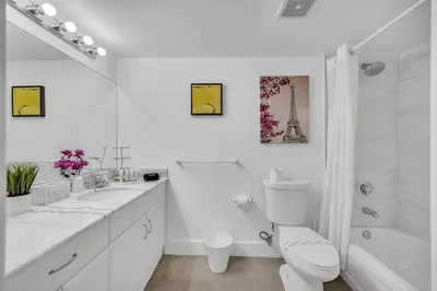 a white bathroom with a toilet and a sink and a shower at 37th floor Amazing spacious unit with parking in Miami