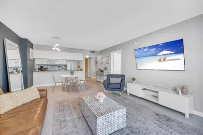 a living room with a couch and a tv on a wall at Ocean front private unit in Miami