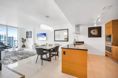 a kitchen and living room with a table and a dining room at 38th floor W residence with amenities in Miami