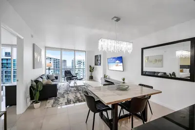 a white living room with a table and chairs at 38th floor W residence with amenities in Miami