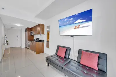 a living room with a couch and a picture of a beach at Highest floor Icon W Brickell Location in Miami