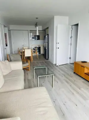 a living room with a couch and a table at Sunny Studio Stay, 2 Full Beds, Coastal Walks Nearby in Hallandale Beach