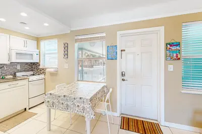a kitchen with a table and a white door at Eternal Coastal Sunshine in Hollywood