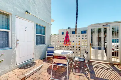 a patio with chairs and a table and a white door at Eternal Coastal Sunshine in Hollywood