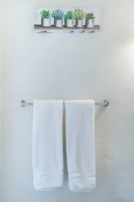 two white towels are hanging on a towel rack at Alma Guest Suite in Miami