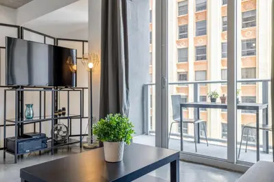 a living room with a tv and a large window at Cozy Downtown Pad- Luxe Rooftop pool gym and more in Miami