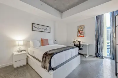 a white bedroom with a bed and a desk at Cozy Downtown Pad- Luxe Rooftop pool gym and more in Miami