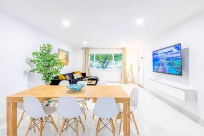 a dining room with a wooden table and white chairs at Angies-10 Min Beach-10 People-Terrace-Families in Hollywood