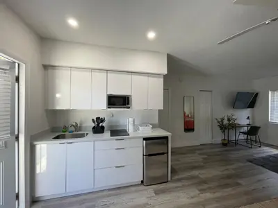 a kitchen with white cabinets and a counter top at Casa Habana Studios in Miami