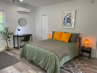 a bedroom with a bed with orange pillows and a desk at Casa Habana Studios in Miami