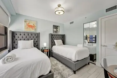 a bedroom with two beds and a mirror at Luxury Beachfront Ocean View Beach Access-817 in Miami Beach