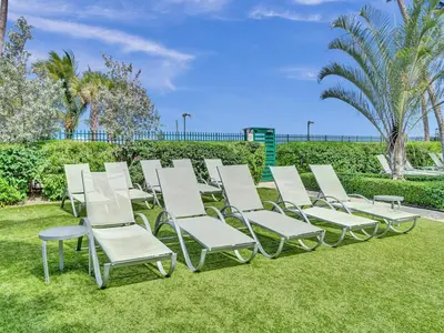 a row of lawn chairs sitting on the grass at Luxury Beachfront Ocean View Beach Access-817 in Miami Beach