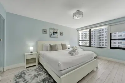 a white bedroom with a bed with a teddy bear on it at Luxury Beachfront Ocean View Beach Access-817 in Miami Beach