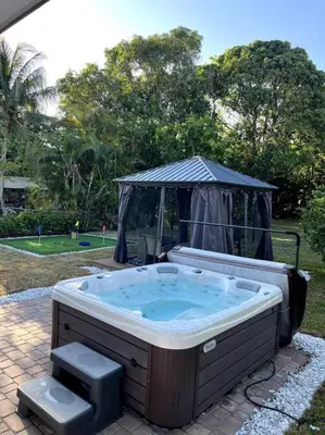 a hot tub in a yard with a gazebo at Modern Tropical Oasis with Arcade, HotTub & MiniGolf in Hollywood