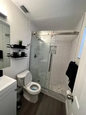 a bathroom with a toilet and a glass shower at Modern Tropical Oasis with Arcade, HotTub & MiniGolf in Hollywood