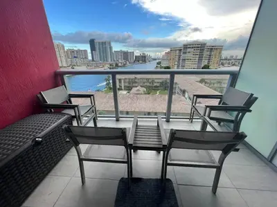a balcony with chairs and a view of the water at Your BeachWalk Retreat, Spacious Studio, Family-Friendly in Hallandale Beach