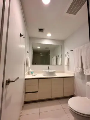a bathroom with a sink and a toilet and a mirror at Oceanview Luxury 2BR with Pool & Beach in Hallandale Beach