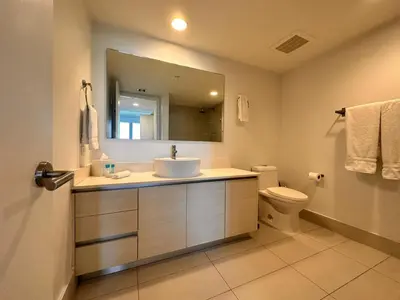 a bathroom with a sink and a mirror and a toilet at Oceanview Luxury 2BR with Pool & Beach in Hallandale Beach