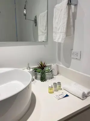 a white bathroom with a sink and a mirror at Hallandale Beach, Pool, Gym & More in Hallandale Beach