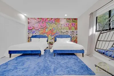two beds in a room with a mural at Game & Chill Manor - Arcade - Pool - Pool table in Fort Lauderdale