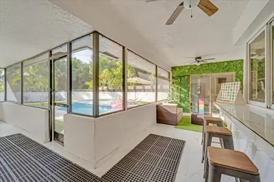 a living room with a pool and windows at Game & Chill Manor - Arcade - Pool - Pool table in Fort Lauderdale