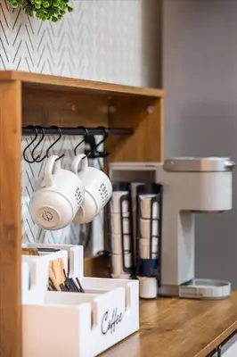 a kitchen counter with two white mugs hanging from a shelf at Game & Chill Manor - Arcade - Pool - Pool table in Fort Lauderdale