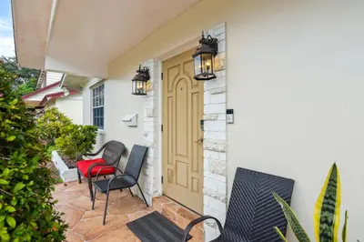 a patio with chairs and a yellow door at Patio and Yard Family-Friendly Miami Oasis! in Miami Gardens