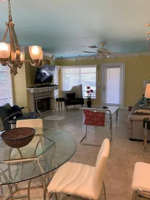 a living room with a glass table and chairs at Manhattan Tower Apartment Hotel in Fort Lauderdale