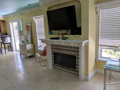 a living room with a fireplace with a tv above it at Manhattan Tower Apartment Hotel in Fort Lauderdale