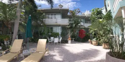 a building with a patio with chairs and plants at Manhattan Tower Apartment Hotel in Fort Lauderdale