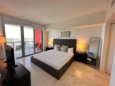 a bedroom with a large bed and a balcony at Oceanview 2BR with Beach & Pool -Hallandale in Hallandale Beach