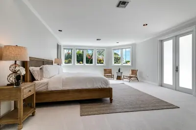a white bedroom with a large bed and windows at Incredible 9 Bedroom 11 Bath Idlewyld Mansion in Fort Lauderdale