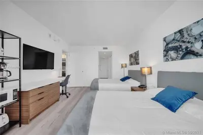 a hotel room with two beds and a flat screen tv at 2 Full Bed BeachWalk Studio, Ocean Nearby, Feels Like Home in Hallandale Beach