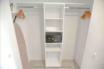 a walk in closet with white shelves and a appliance at Sophisticated Beach Escape, Breathtaking Views & Comfort -2A in Hallandale Beach