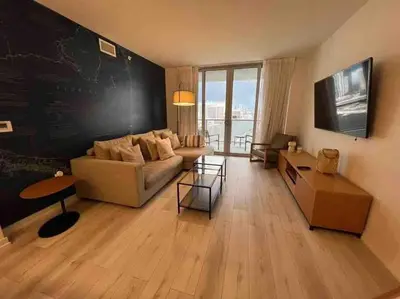 a living room with a couch and a chalkboard wall at Oceanfront Elegance, Full Kitchen & Miami Beach Charm -1A in Hallandale Beach