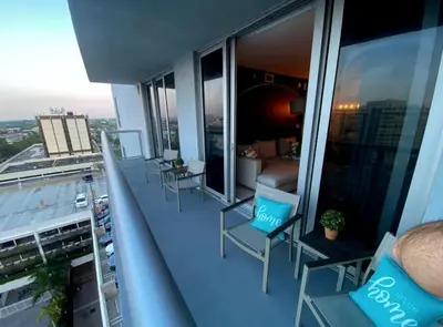 a balcony with chairs and a couch on a building at Cozy Beach Apartment with Full Kitchen -A in Hallandale Beach