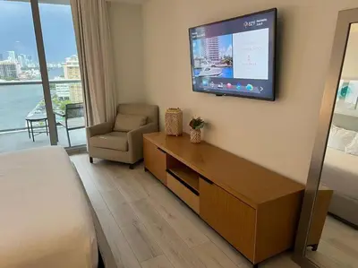 a hotel room with a bed and a tv on the wall at Relax in Style, Miami Beach Apt with Full Kitchen and Dreamy Views -A in Hallandale Beach