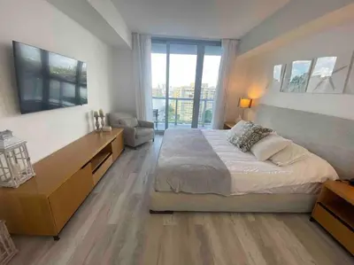 a bedroom with a large bed and a large window at Stylish Beach Condo with Full Kitchen -A in Hallandale Beach