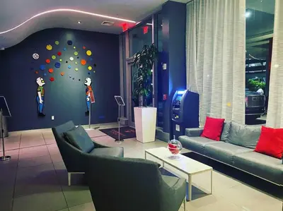 a living room with couches and a wall with a ball wall at Stylish Beach Condo with Full Kitchen -A in Hallandale Beach