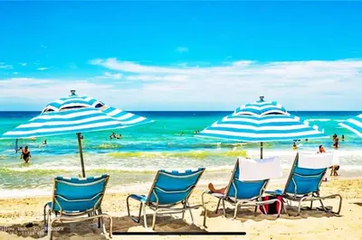 a group of chairs and umbrellas on a beach at Beachy Vibes Studio, 2 Full Beds, Near Everything in Hallandale Beach