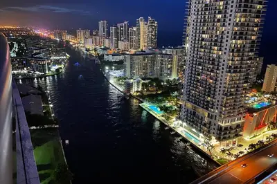 a view of a city at night with a river at Beachy Vibes Studio, 2 Full Beds, Near Everything in Hallandale Beach