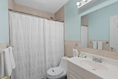 a bathroom with a toilet and a sink and a mirror at Stylish 2BR Villa full kitchen 10 mins from Beach in Fort Lauderdale