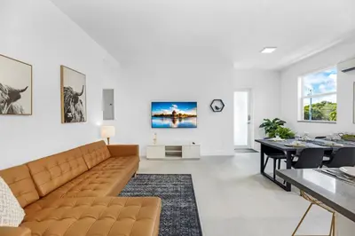 a living room with a couch and a dining room at Up to 12 Guests! Modern villa near Wynwood in Miami